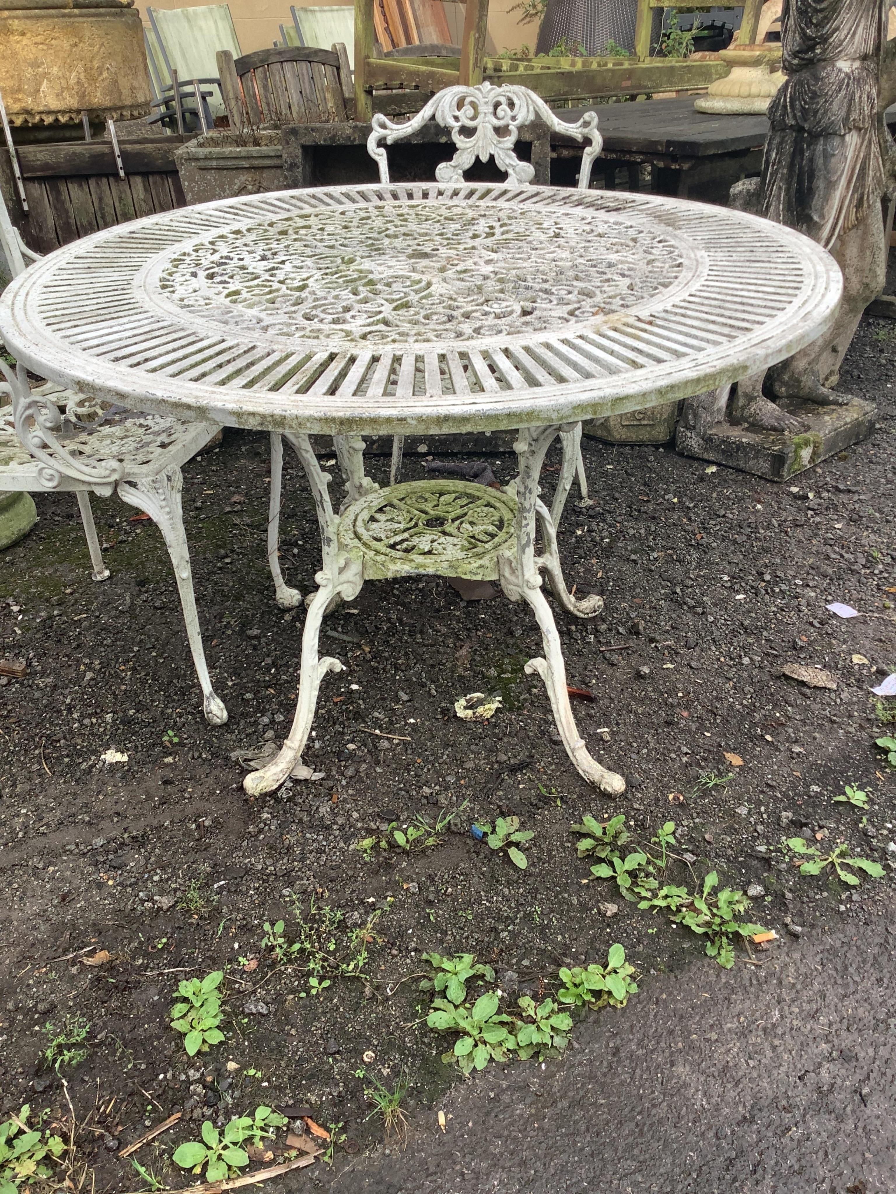 A Victorian style painted aluminium circular garden table, diameter 106cm, height 70cm and four chairs. Condition - good